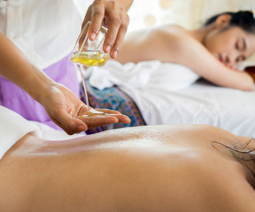 Two massage tables side by side in a softly lit private spa suite