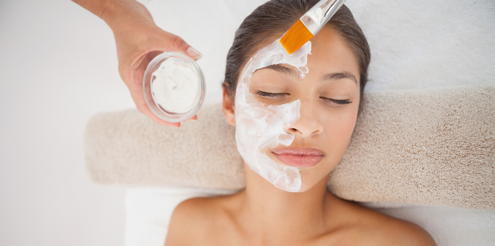 Esthetician applying a vitamin C mask during a brightening facial
