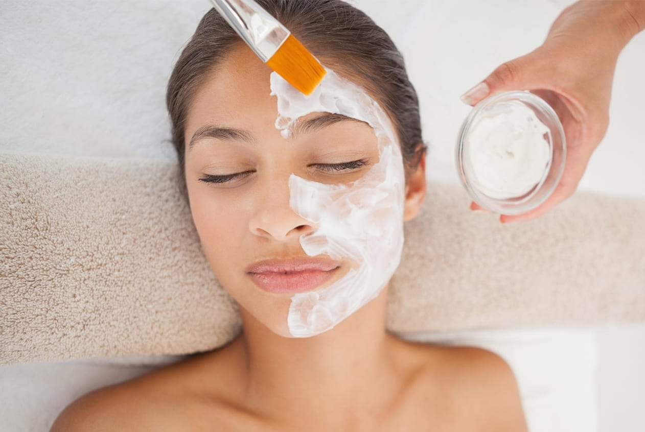 Esthetician applying an organic Eminence facial treatment